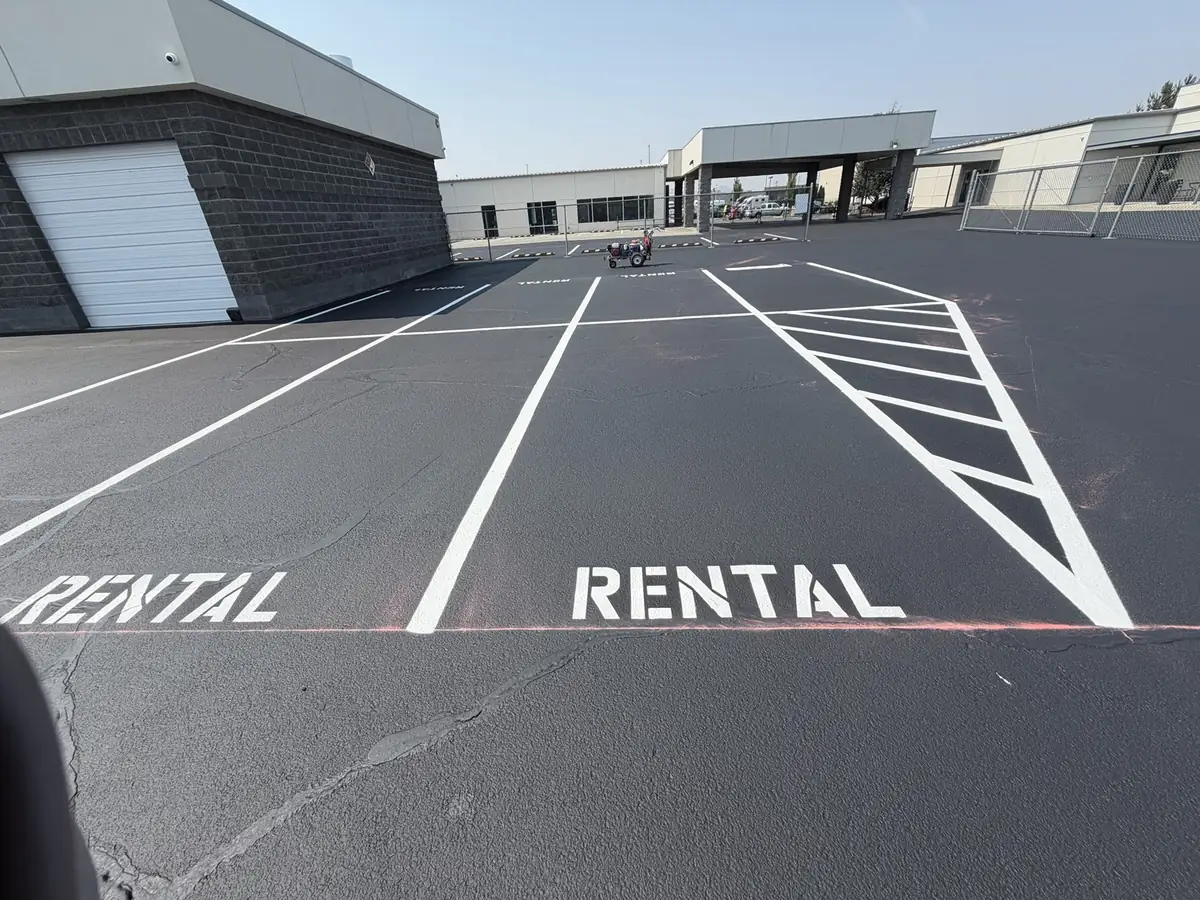 RENTAL stall stencils and hatched no-parking markings painted across an industrial yard in Pasco WA