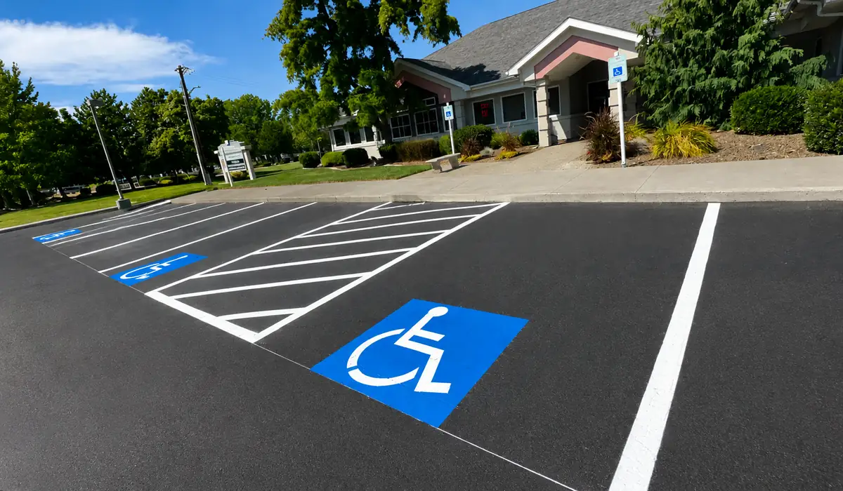 Newly painted blue ADA accessible parking stall with white hatched loading zone at a Tri-Cities medical office
