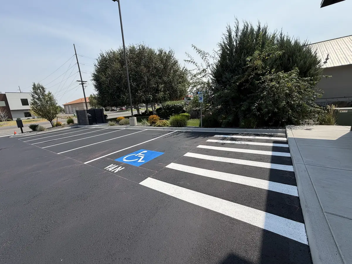 Fresh crosswalk striping and ADA stall markings on a sealcoated office parking lot in Kennewick WA