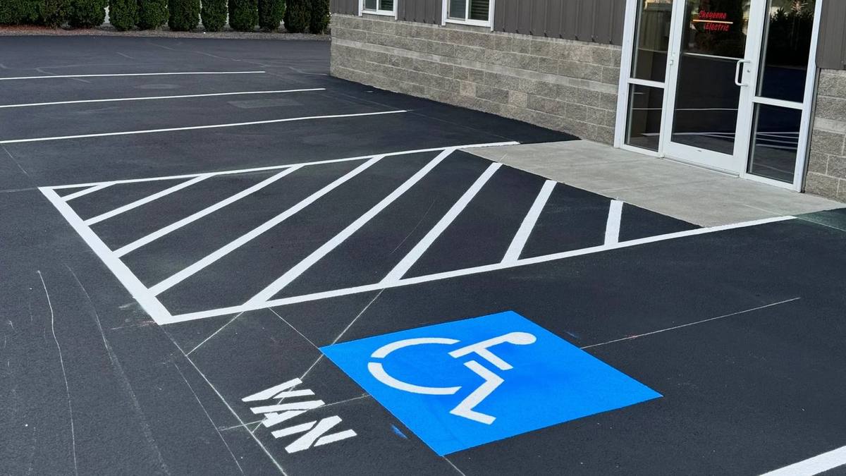 Freshly painted ADA accessible parking stall with blue and white striping on a Tri-Cities commercial parking lot